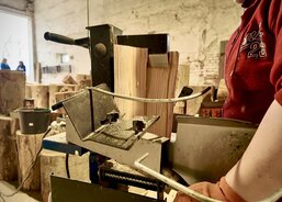 Nařezané dřevo štípají pracovníci na štípačce, aby bylo dřevo ihned k použití.